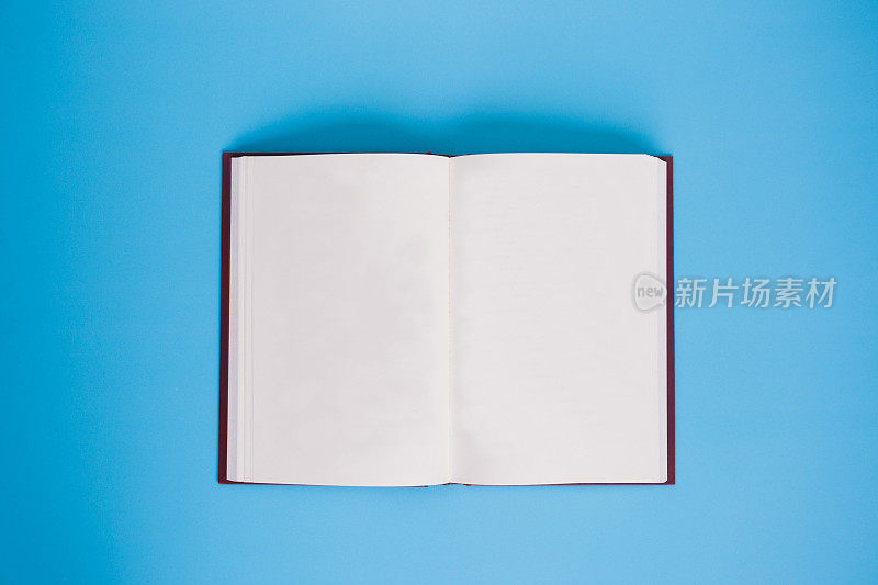 打开书与空白页在明亮的蓝色背景-与副本空间。
