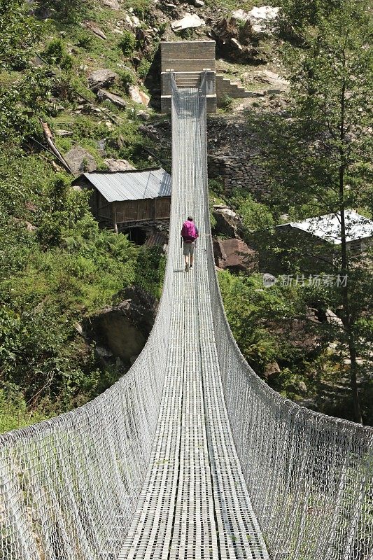 一名男子在安纳普尔纳徒步穿越一座吊桥