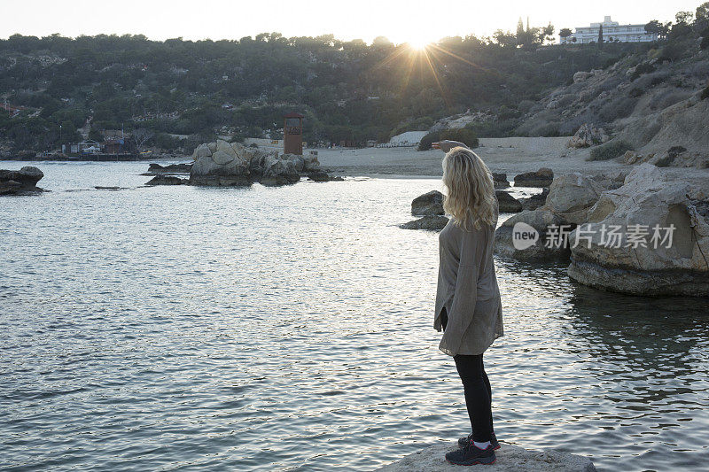 一个女人在海湾上看日落