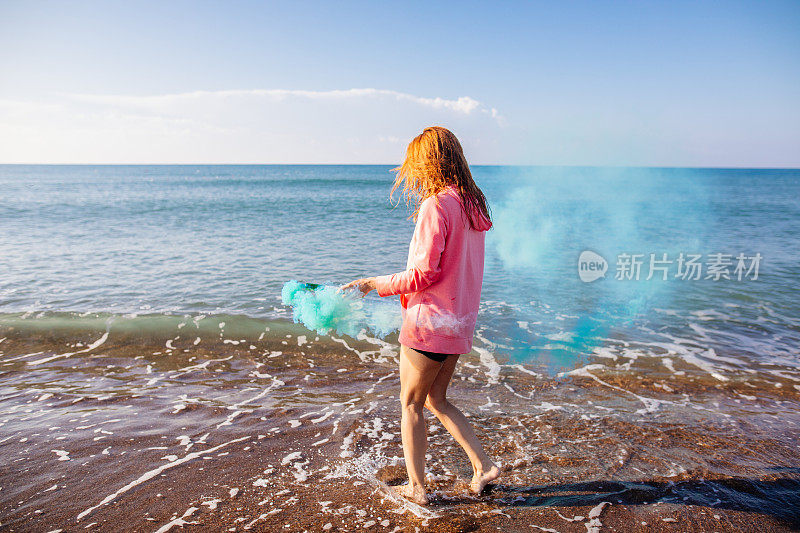 在海滩上玩烟雾弹的女人