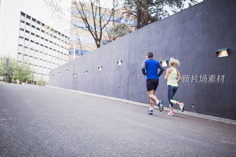 年轻情侣，运动员，一起在城市环境中慢跑
