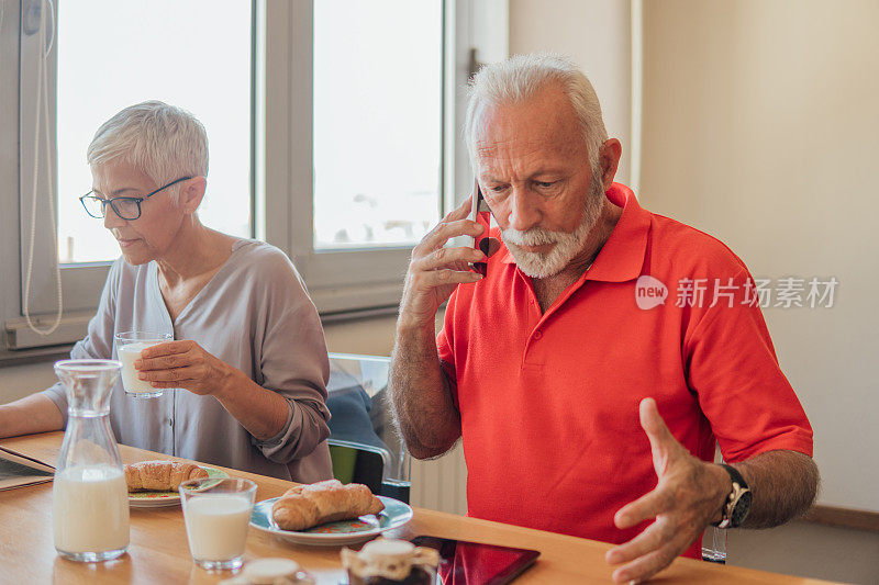 一对紧张的情侣一边吃早餐一边用手机