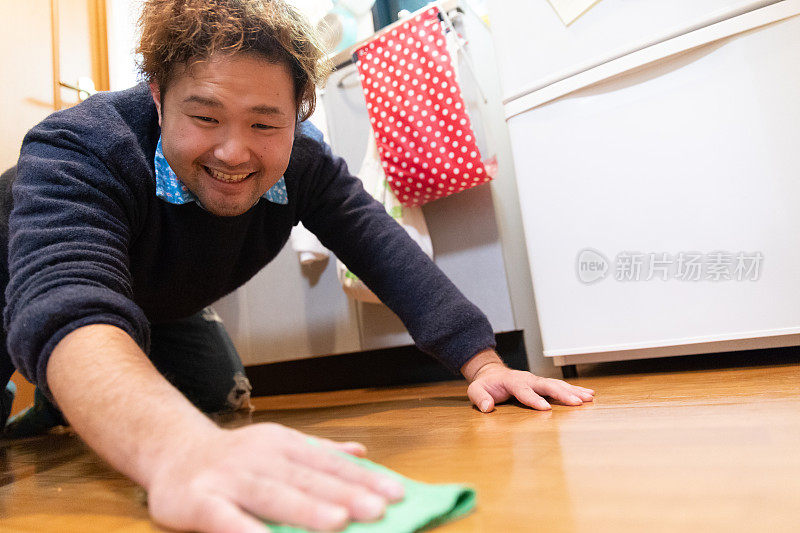 一名日本男子正在清理厨房地板