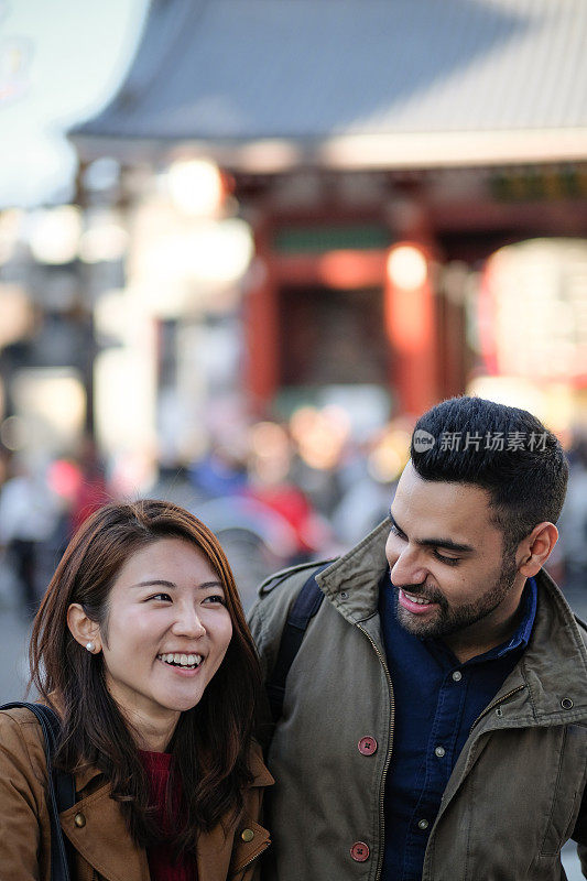 在东京旅游景点的街道上，一名女子和一名男子在交谈