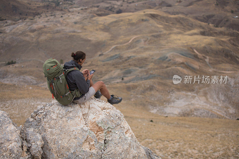 登山者在山顶使用智能手机