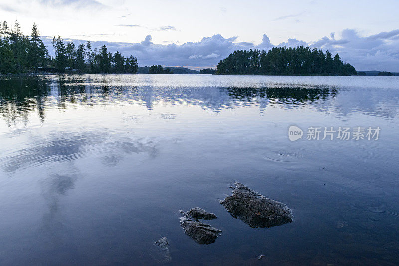 在一个夏天的晚上，瑞典平静的斯道拉湖上的日落