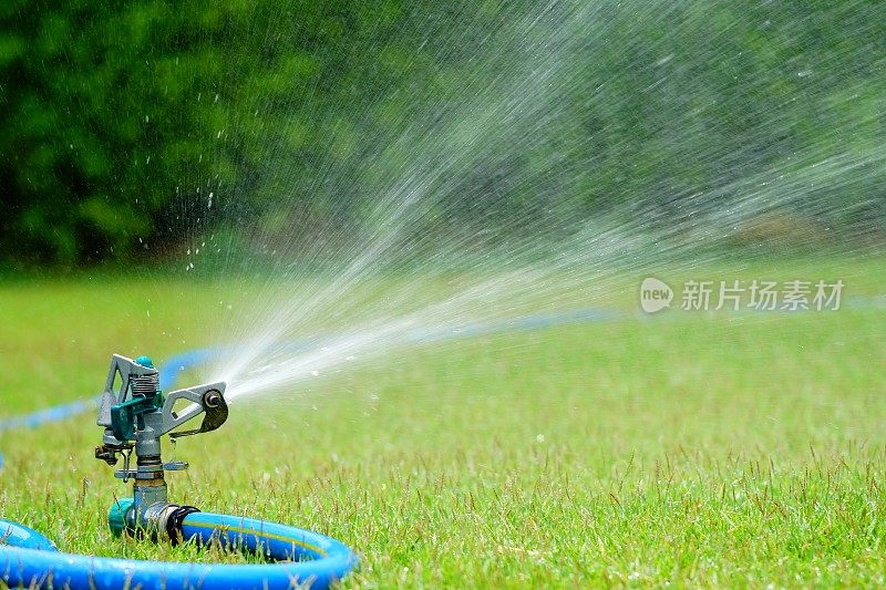 洒水车在绿色草坪上喷水