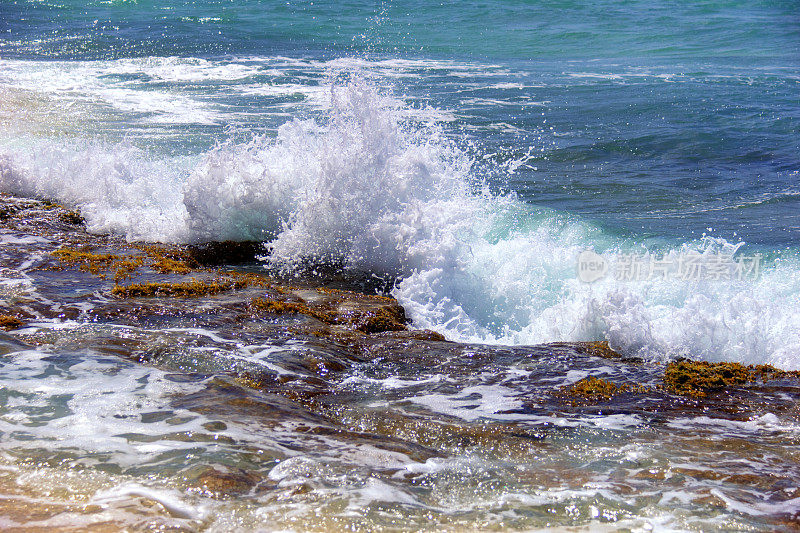 海浪拍打着海滩上的石头。