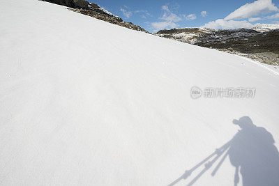 风景摄影师在冰雪覆盖的山脉在约顿海门国家公园