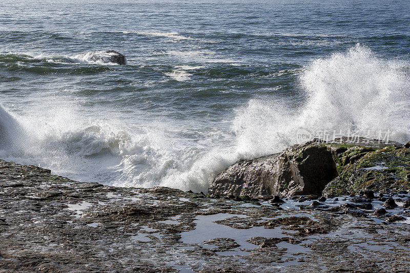 汹涌的海浪拍打着岸边的岩石