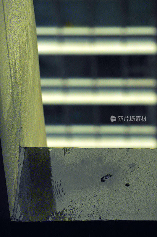 水滴落在摩天大楼肮脏的混凝土地板上