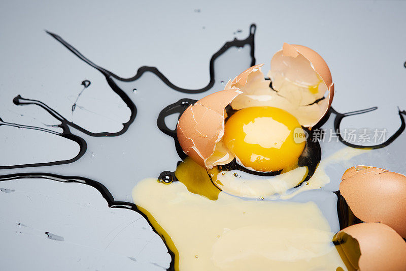 一个鸡蛋掉了下来，摔在黑色的地上