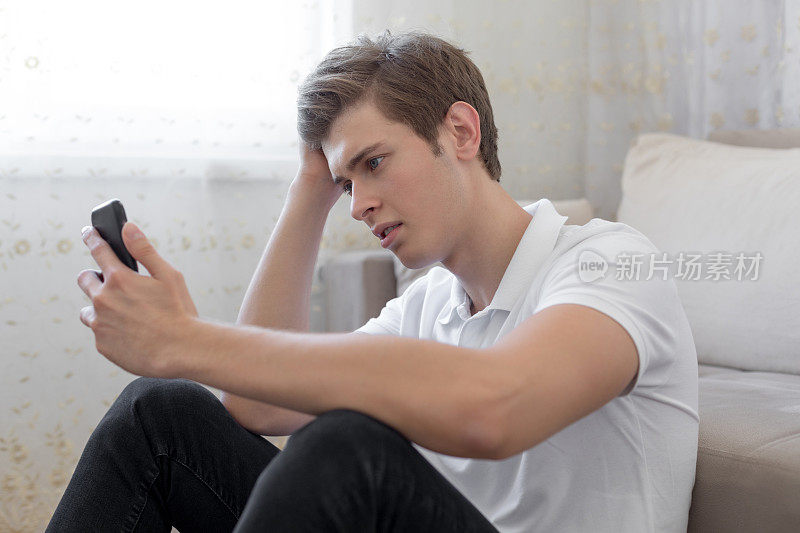 悲伤的男人在看手机