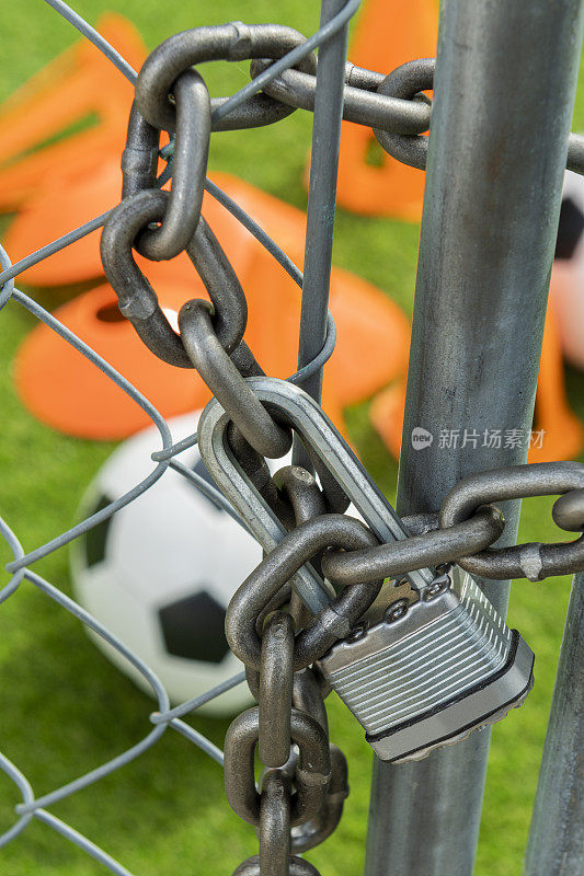 用挂锁和足球用具锁上的铁链栅栏门