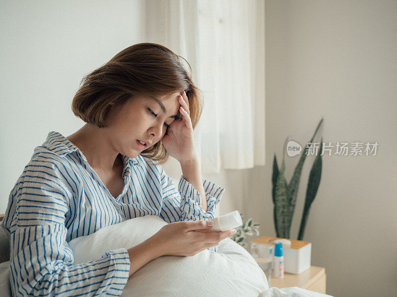 年轻女子拿着止痛药瓶读处方