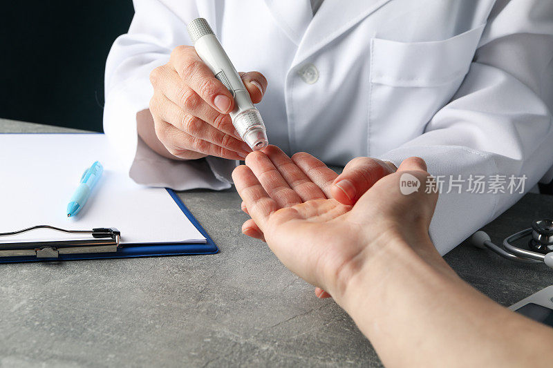 医生在灰色的桌子上检查糖尿病患者的血糖水平