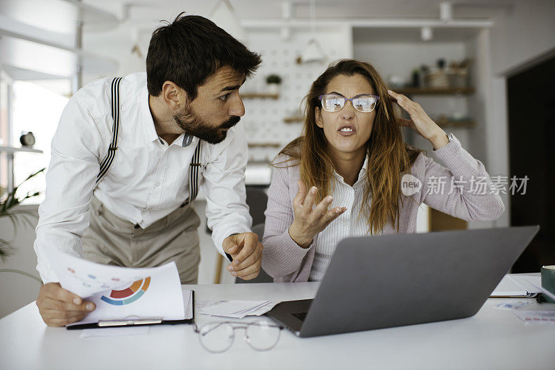 一对沮丧的夫妇在家里用笔记本电脑上的库存照片查看账单