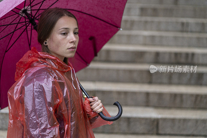 一个悲伤的少女在雨天的楼梯上