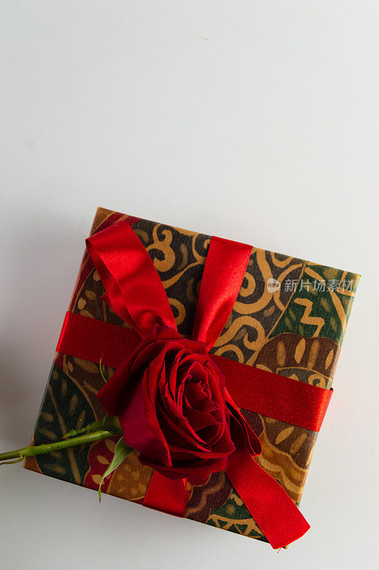 礼盒与红色蝴蝶结和玫瑰在白色的背景