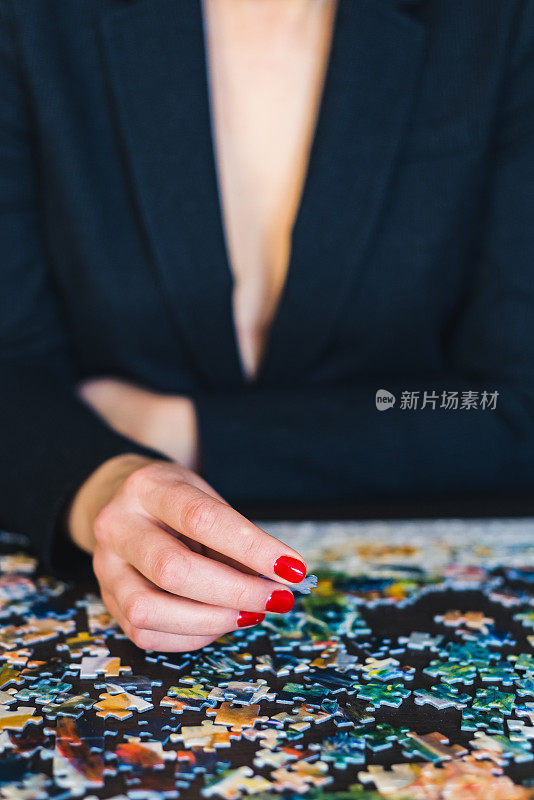 一个女性的手在把拼图碎片放回原位