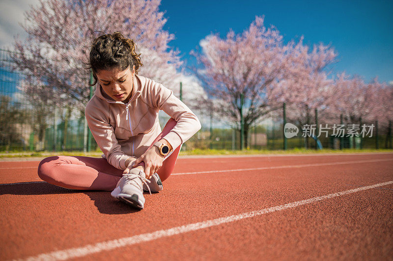 运动的年轻女子脚踝受伤。