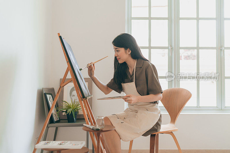 亚洲女画家在她的家庭工作室创作艺术