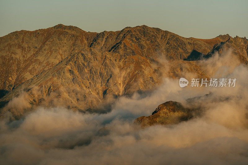 塔特拉山脉和日落的秋景。云朵飘浮于山峰之上