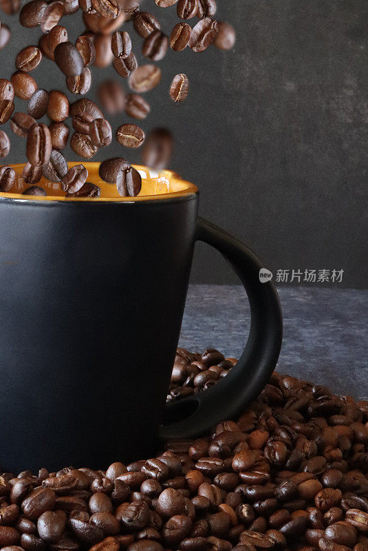 中国近景，咖啡杯周围环绕着烤过的咖啡豆，整颗咖啡豆被倒进杯子里，黑色背景，聚焦前景