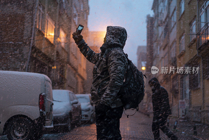 冬天，满脸胡须的中年男子在下雪的日子里在伊斯坦布尔街头的肖像。