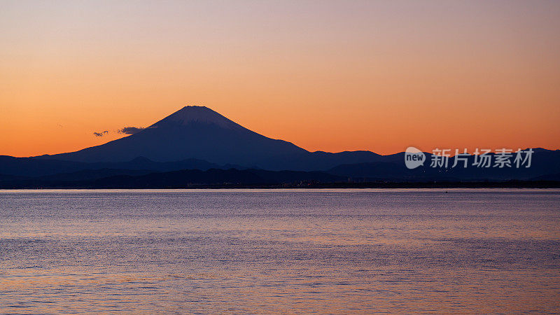 夕阳下，沙滩上的富士山轮廓