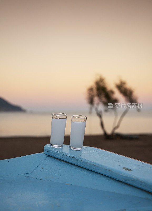 日落时分在海滩上喝两杯传统的土耳其拉基酒