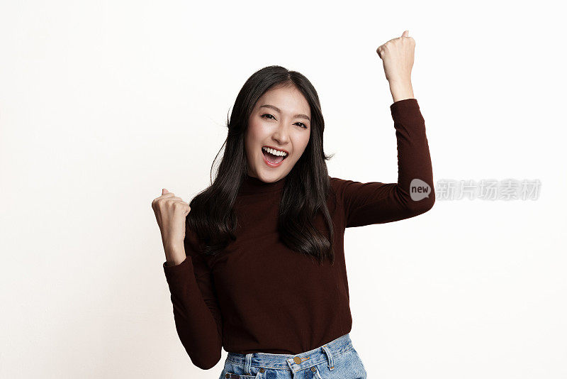 工作室肖像照片的年轻亚洲妇女感到高兴或兴奋，举手表示享受的情绪，面部表情。