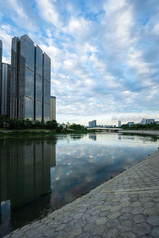 阳光明媚的日子里，沿河有现代化的建筑和桥梁