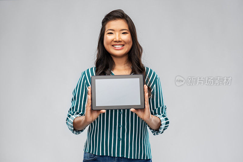 快乐的亚洲女人使用平板电脑