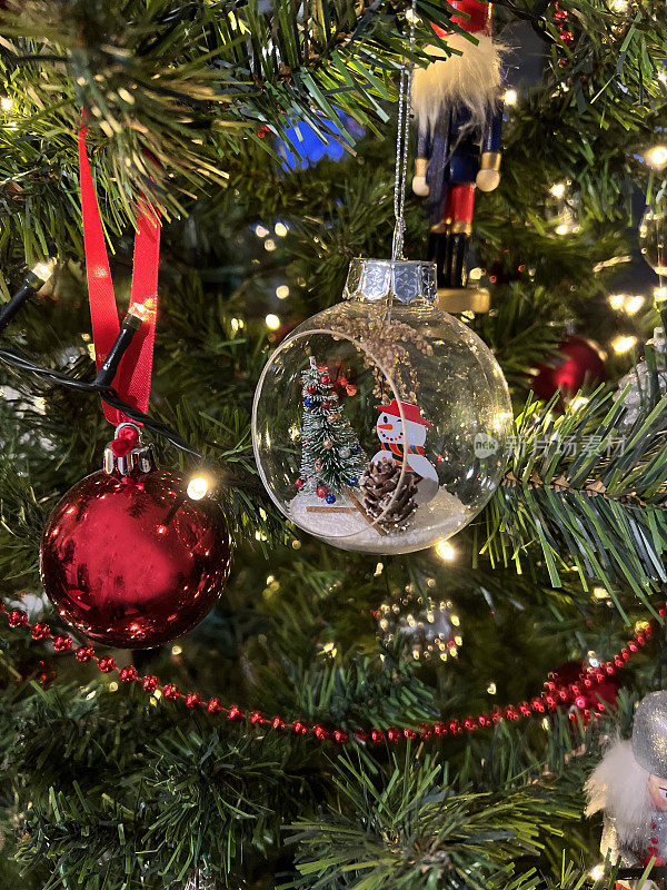 可爱的雪人在玻璃装饰品挂在圣诞树上