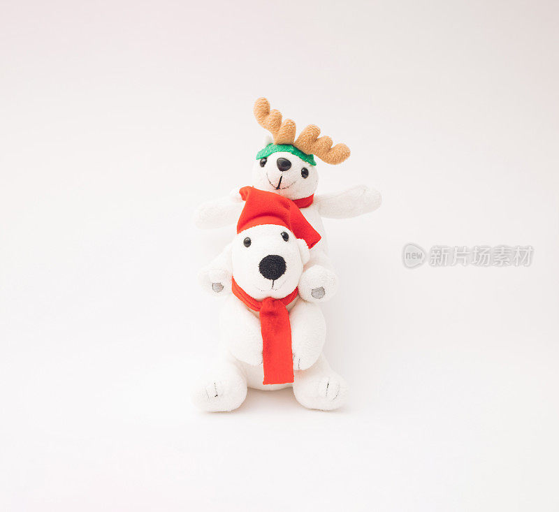 两只快乐的毛绒玩具北极熊，戴着圣诞老人的帽子，围巾和驯鹿鹿角。