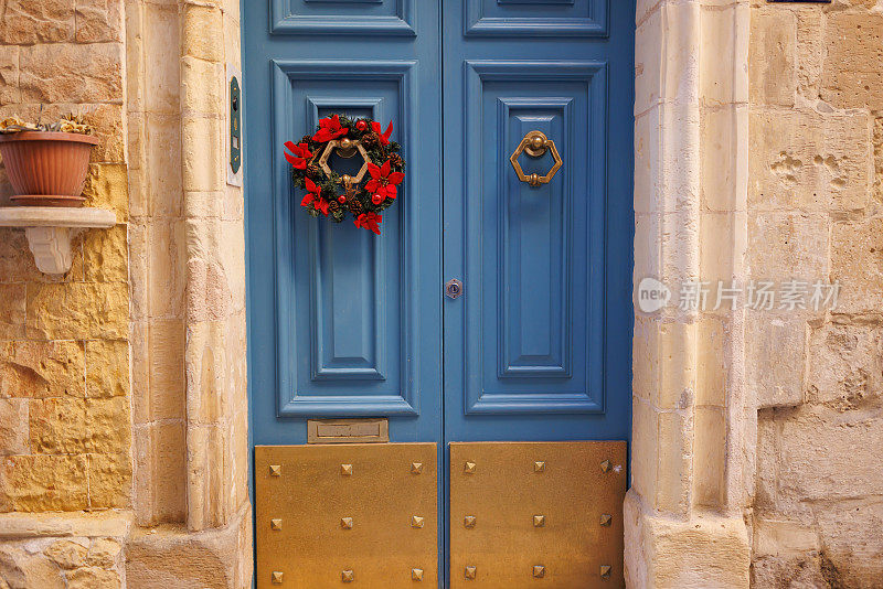 蓝色的木制前门装饰着圣诞花环