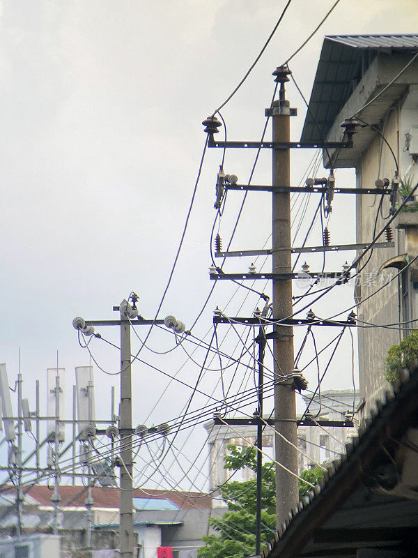 电线杆，建筑物前电线杆上的电线和电话线缠绕在一起