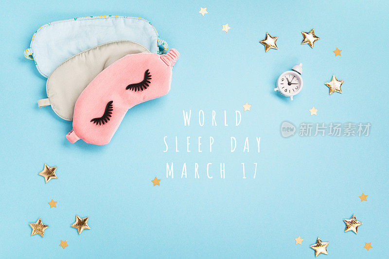 睡眠面具，金色星星和闹钟在蓝色背景。世界睡眠日概念。