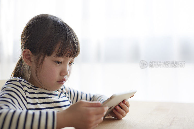 女孩在桌子上看着平板电脑