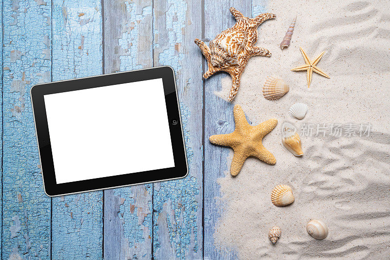 夏天，海滩和度假的概念与自由文本空间。前视图。平面布局与空白的平板，大海星和海贝壳和各种海贝壳和细沙滩在一个古老的蓝色木板背景