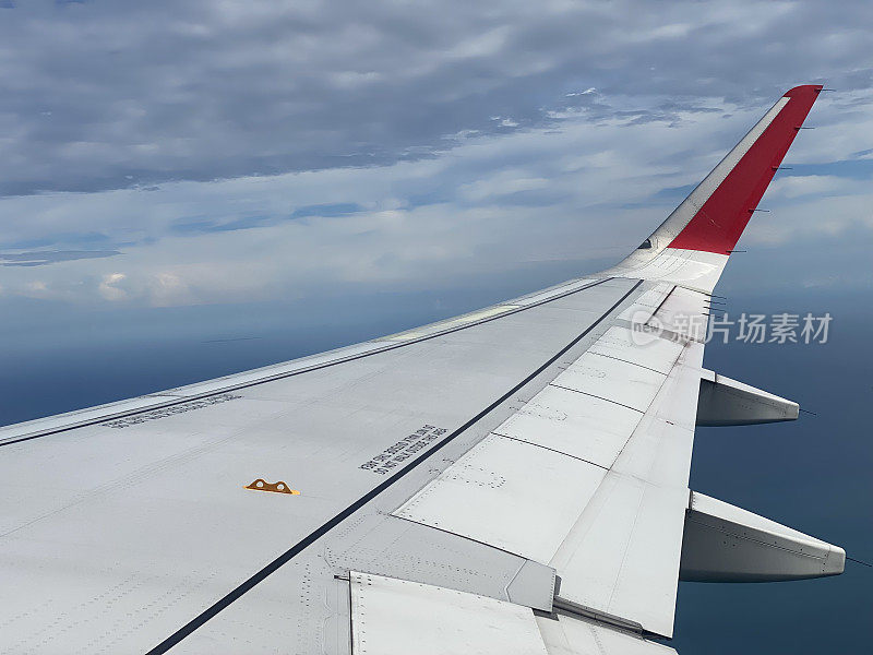 透过窗户看飞机在机翼上飞行，蓝天很漂亮