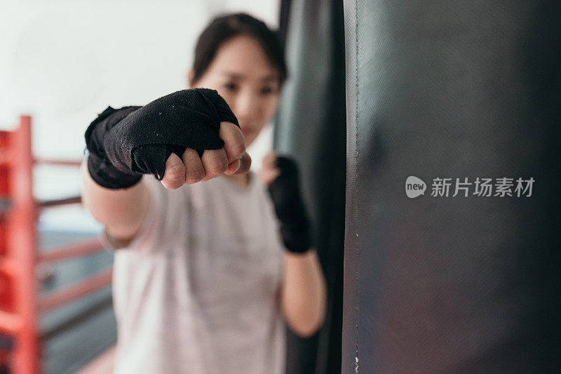 在训练馆里练习自由搏击的亚洲女子