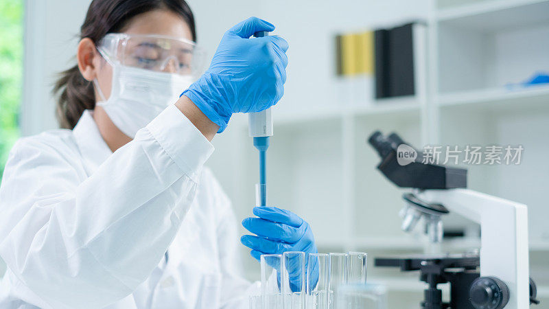 亚洲女科学家正在实验室把蓝色液体物质滴在科学试管里。科学概念，生物化学，化学，诊断，生物技术。物质研究分析实验