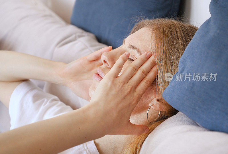压力山大的金发女人双手抱头偏头痛。精神压力和疼痛概念视频
