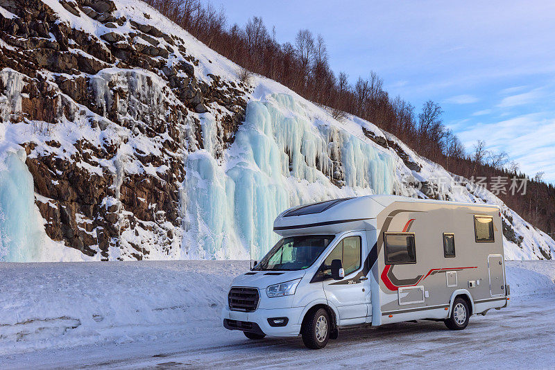挪威冬天，美丽的蓝色冰墙下的露营者