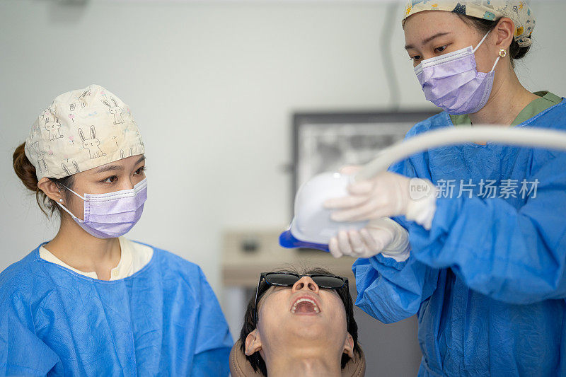 戴口罩和眼镜的女牙医正在治疗