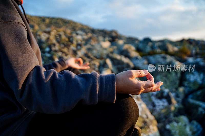 手印在手上，手指交叉在手印上，在山上冥想，身体的一部分的碎片，手放在膝盖上，练习瑜伽。
