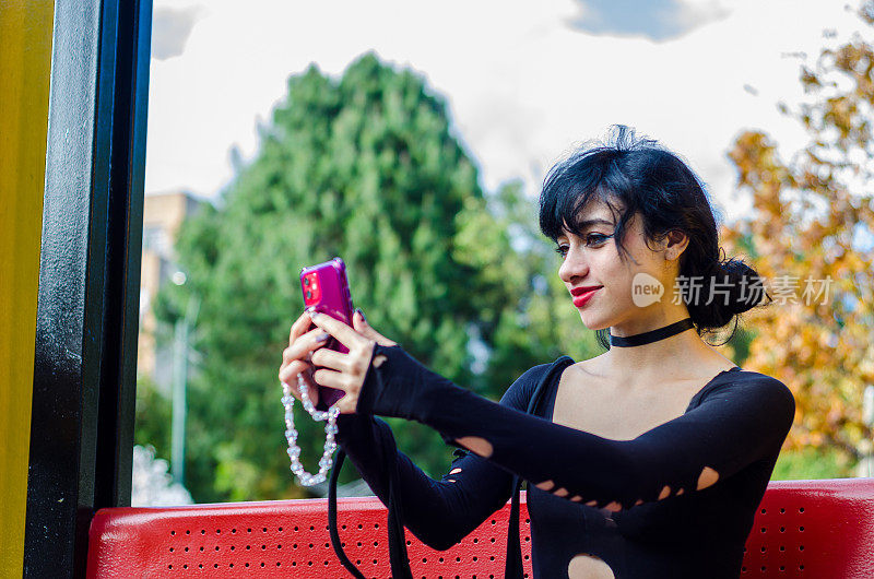 哥伦比亚女子在公园里用智能手机自拍的照片