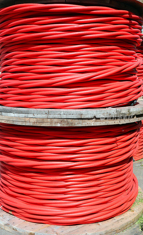 大量成卷的粗红色电力电缆，用于输送数千千伏的绝缘高压电流
